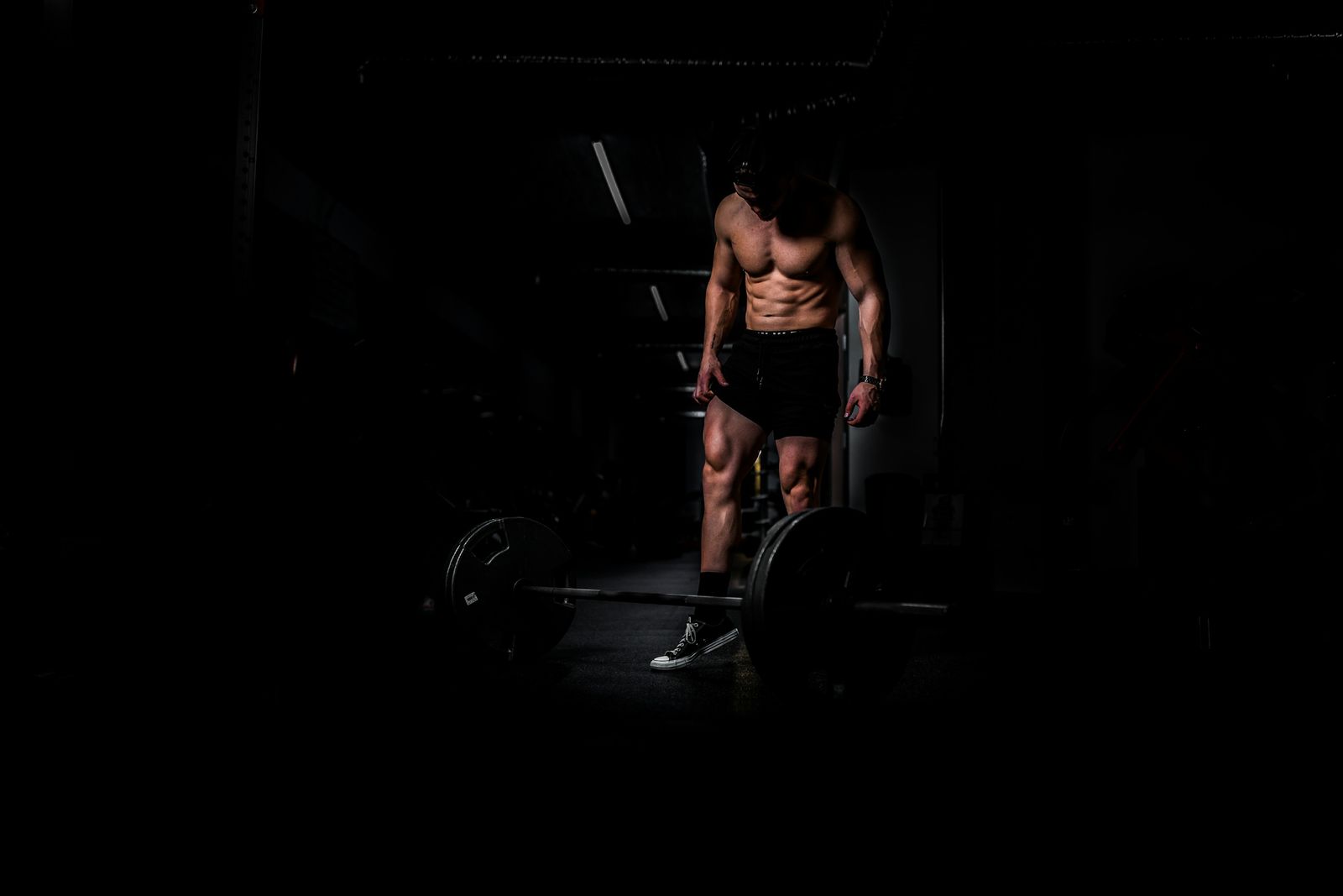 Athlete deadlifting in a dark gym