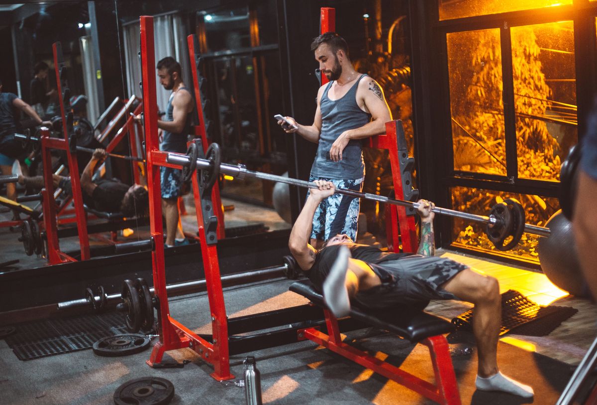 Athlete logging a workout on their phone between sets